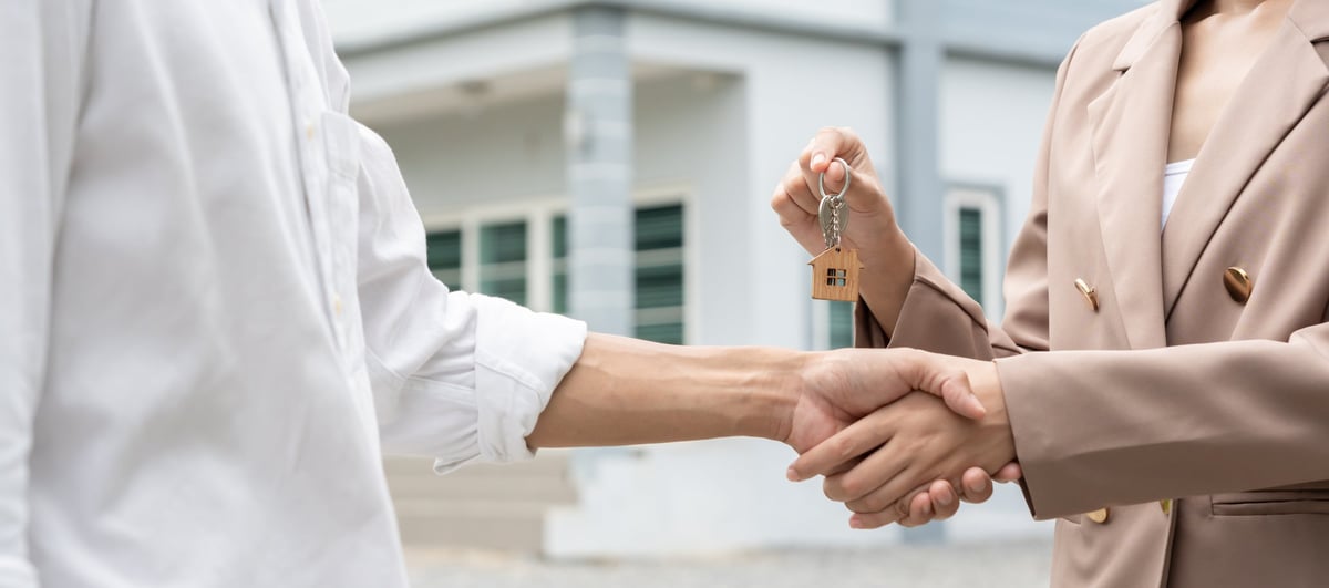 Real estate agent handing over house keys — every homeowner deserves protection
