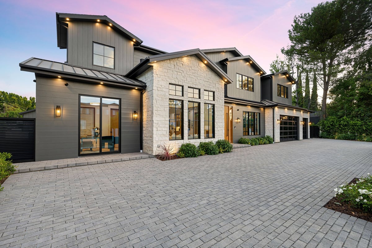 Modern luxury home exterior at sunset — we help homeowners at every price point
