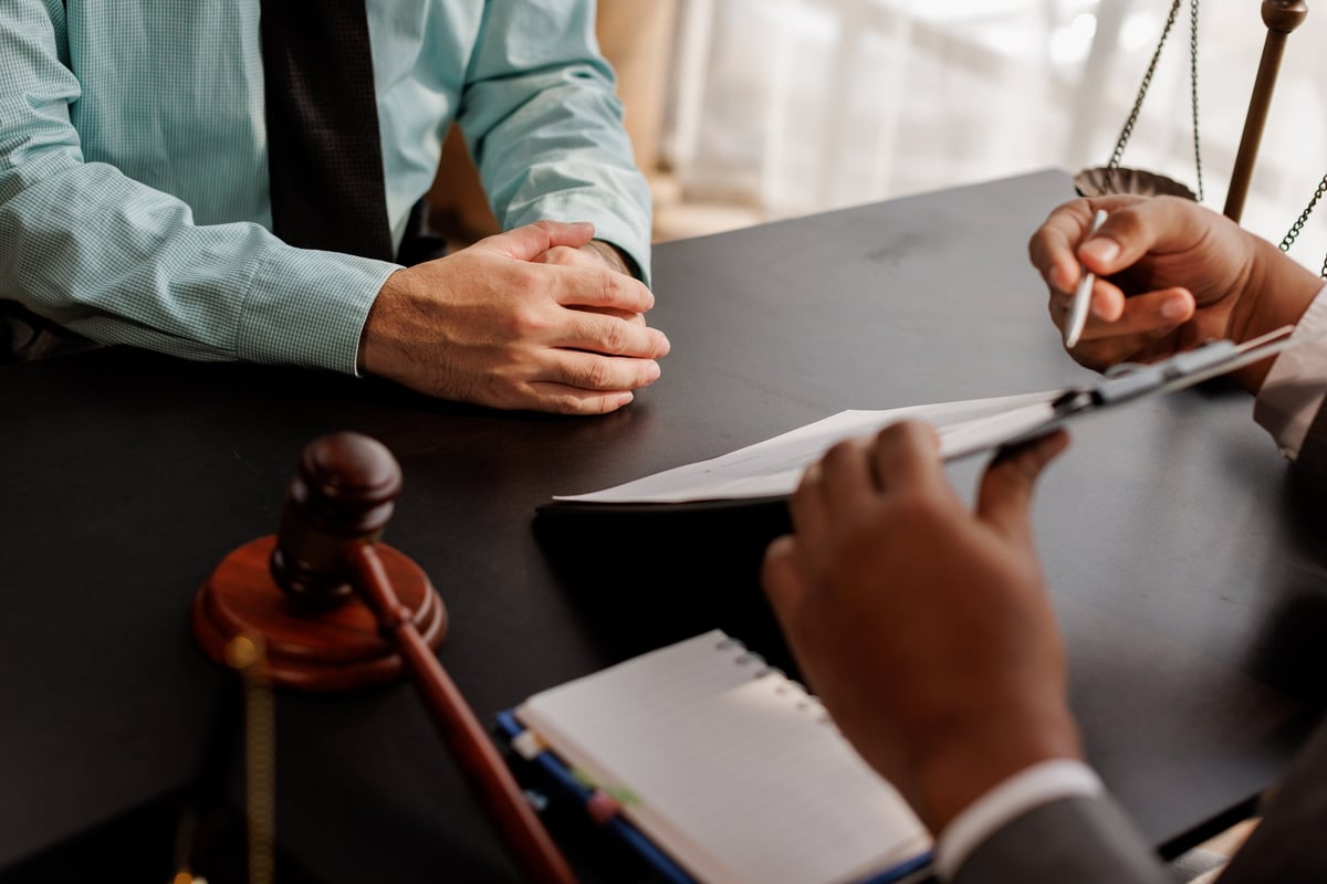 Professional legal consultation meeting — attorney reviewing documents with client