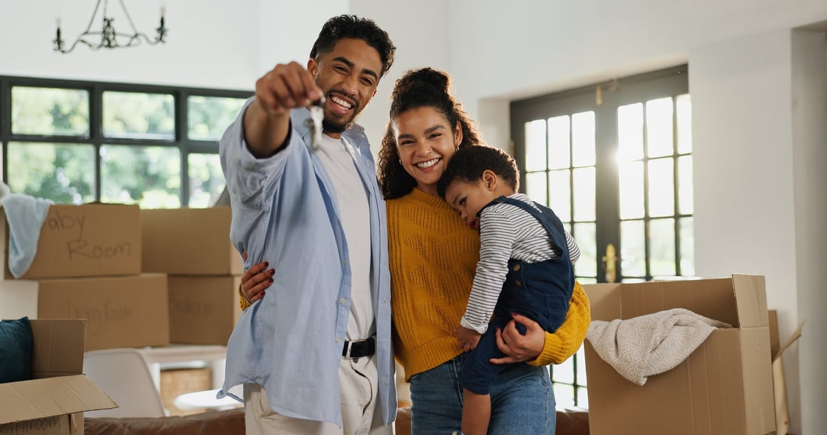 Happy family with house keys in their new home — the dream we protect
