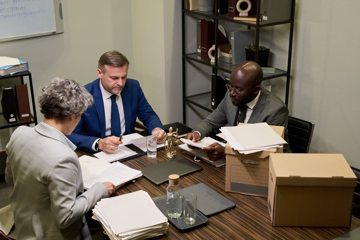 Professional legal team reviewing documents with client in modern office